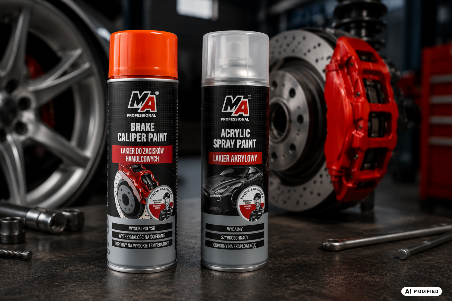 Dwa lakiery techniczne MA Professional w sprayu do zastosowań motoryzacyjnych, ustawione w warsztacie przy tarczy hamulcowej, czerwonym zacisku i feldze.